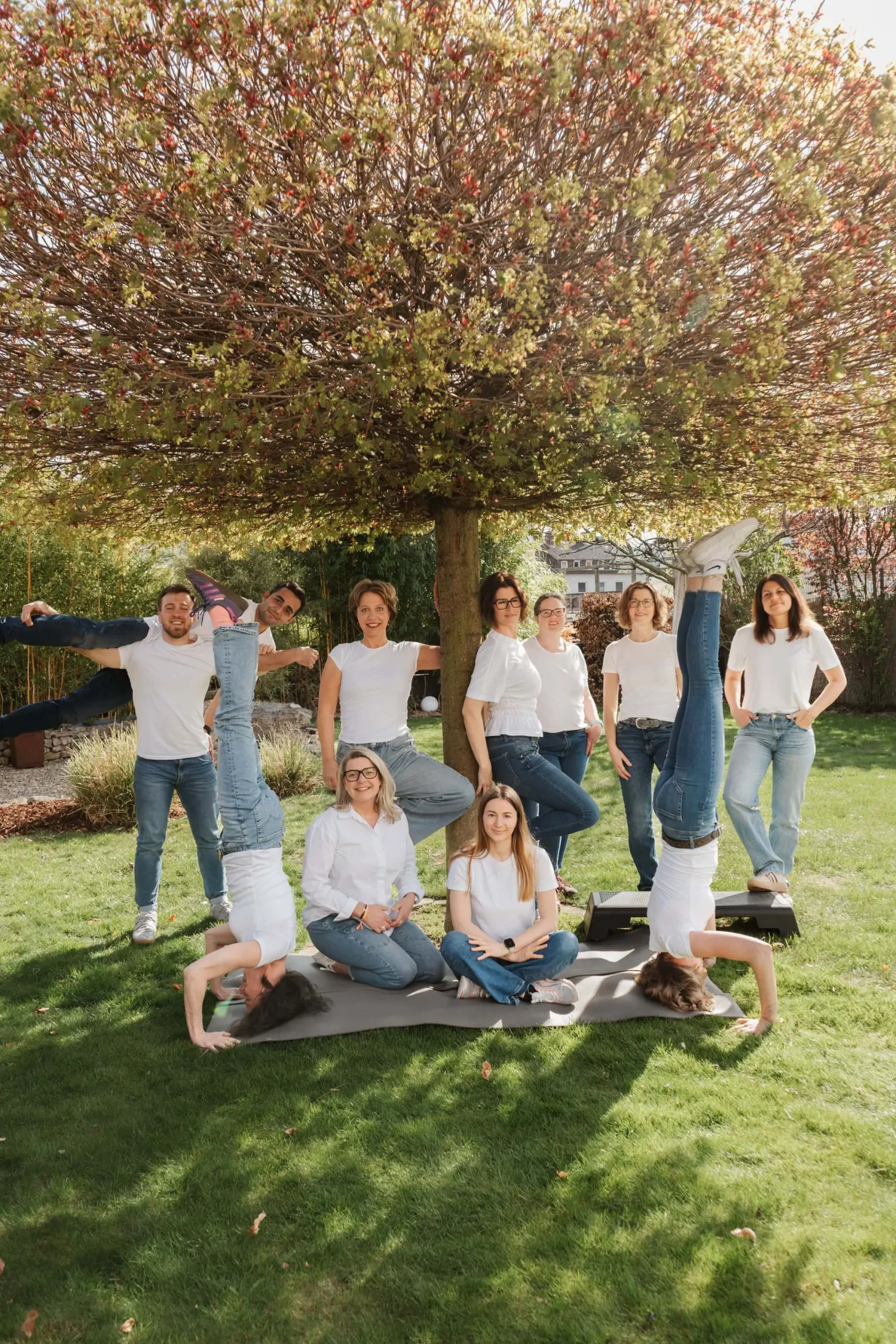 Team von PhysioVital Alfeld bei einem gemeinsamen Gruppenfoto im Garten der Praxis